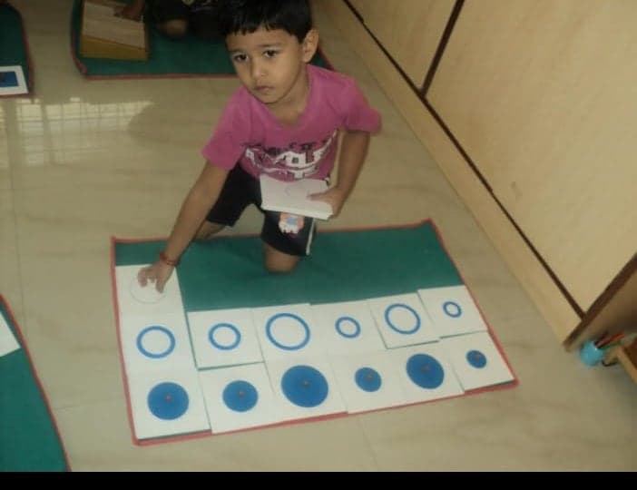 A child arranging Montessori knobbed discs