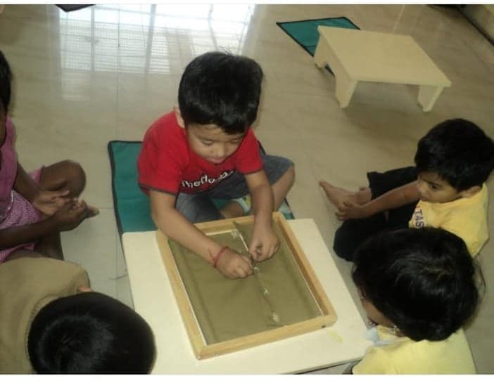 Children at work with the sandpaper tracing tray