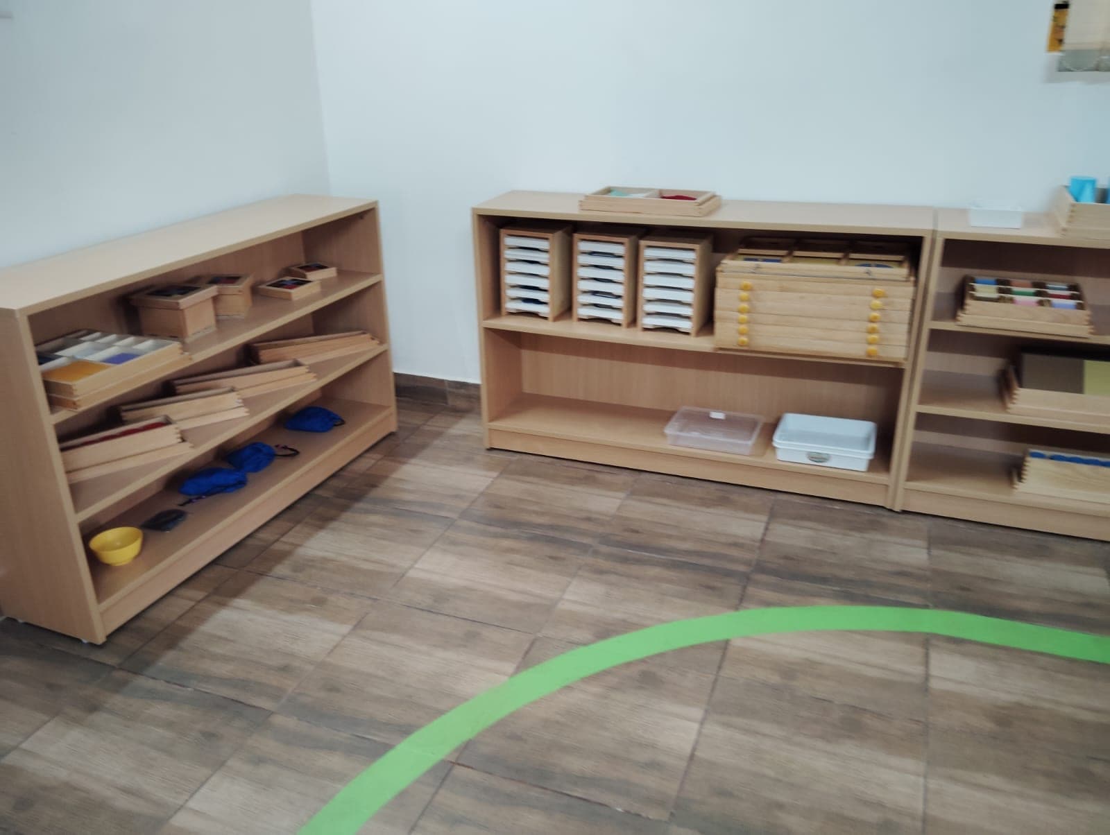 Natural-wood Montessori shelves at child height